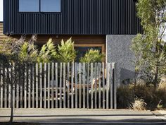 the house is made up of black and white sidings, with wooden slats on each side