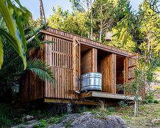 a small wooden building with a metal tub in the middle of it's roof