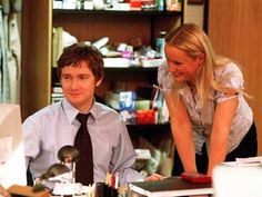 a man and woman sitting at a desk in an office