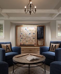 a living room with two blue chairs and a coffee table in front of a window