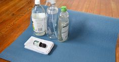 two bottles of water and an empty bottle on a mat