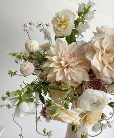 a vase filled with lots of white and pink flowers