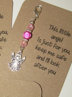 two key chains with charms attached to them on top of a card that says, this little angel is just for you keep me safe and i'll look after you