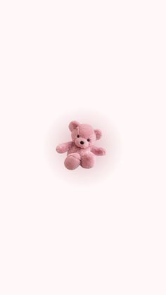 a pink teddy bear sitting on top of a white surface