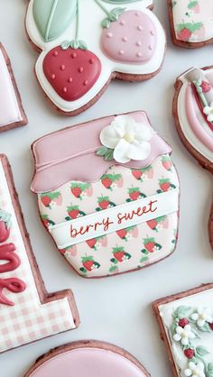 some decorated cookies are laying on a white table top with the words berry sweet spelled in red