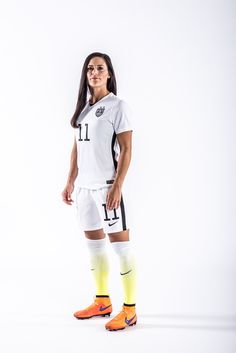 a female soccer player is posing for a photo wearing her uniform and socks with the number 11 on it