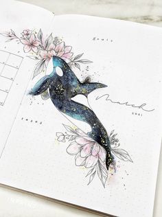 an open notebook with a whale and flowers on it