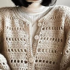 a woman with black hair wearing a white sweater