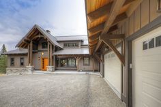 a large house sitting on top of a gravel lot next to a garage and driveway