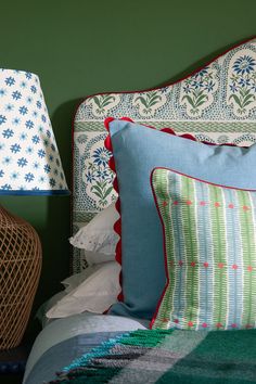 a bed topped with pillows and lamps next to each other