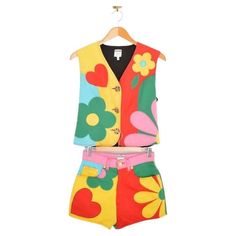 Superb, Rare colourful 1990's Moschino Two Piece set, comprising of a button down vest & matching high waisted cotton shorts. MADE IN ITALY Features: High waisted shorts x4 pocket design shorts Gold tone flower buttons & hardware Enamel detailed vest buttons Adjustable tie to the back of the Vest Measurements given in inches: Pit to Pit: 18.5'' Vest Length: 19'' Shorts Waist: 27'' Recommended Size: UK6-8 Condition 9/10. Spring Fitted Patchwork Sets, Spring Cotton Patchwork Sets, Spring Cotton Sets With Patchwork, Cotton Patchwork Sets For Spring, Spring Cotton Sets With Patchwork Details, Retro Multicolor Summer Sets, Spring Multicolor Patchwork Sets, Moschino Fashion, Franco Moschino