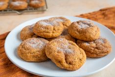 a white plate topped with cookies covered in powdered sugar on top of a table