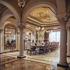 an elegant dining room with columns and chandelier