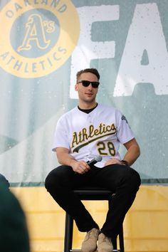 a baseball player sitting on top of a stool