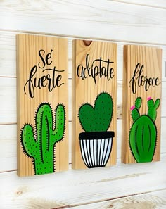 three wooden signs with cactus designs on them