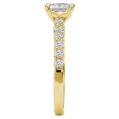 a yellow gold engagement ring with an oval cut diamond in the center and side stones