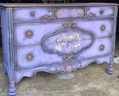 an old dresser painted in purple and gold