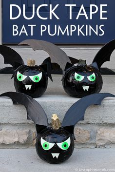 three black pumpkins with green eyes and bats painted on them are sitting in front of a sign that says duck tape bat pumpkins