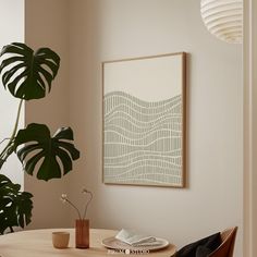 a room with a table, chair and potted plant on the wall next to it