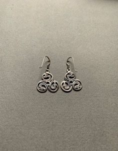 This pair of dragon triskelion dangle earrings are made of sterling silver. They are 2x2cm and come with a pair of earring backs. Symbolic Sterling Silver Drop Earrings, Silver Symbolic Hypoallergenic Earrings, Symbolic Silver Earrings With Ear Wire, Silver Hypoallergenic Symbolic Earrings, Black Sterling Silver Symbolic Earrings, Black Symbolic Sterling Silver Earrings, Symbolic Black Sterling Silver Earrings, Silver Dangle Earrings, Sterling Silver Dangle Earrings