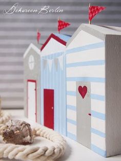 two small wooden houses sitting next to each other on top of a white tablecloth