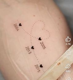 the tattoo on someone's stomach has hearts and numbers drawn on it, as well as arrows