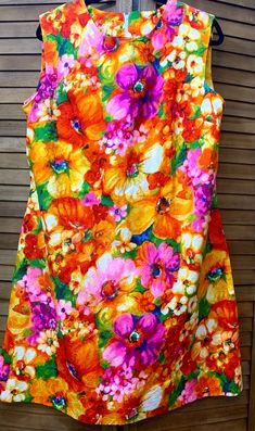 This vintage 1970's Channel 1 by Bill Sims brand sleeveless A-line dress in size 20 ½ is the perfect summer dress Stylized, colorful flowers are scattered across this dress.  Features include darts at the bust and on either side of the back zipper to give shape to this garment as well as a side pocket.  The traditional A-line design is classic, but the fabric design makes it stand out.  Dress it up with a jacket for work or add accessories for any casual or formal event this summer.   Size: 20 ½ Hawaiian Clothing, Hawaiian Outfit, Line Design, Dress Clothes For Women, Side Pocket, Perfect Summer, Formal Event, Colorful Flowers, Size 20