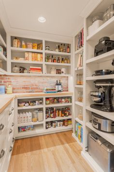 an organized pantry with lots of shelves and appliances on the counter top, along with wooden flooring