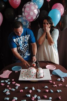 a man and woman cutting into a cake with balloons in the background at a birthday party