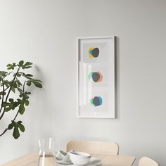 a dining room table with plates and cups on it next to a potted plant