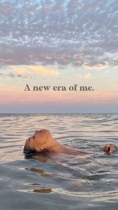 a woman floating on top of a body of water under a cloudy sky with the words, a new era of me