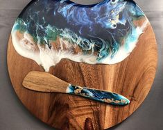 a wooden board with a blue and white painting on it next to a spatula