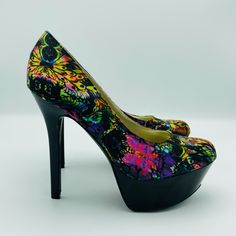 a pair of colorful high heels on top of a white surface with black soles