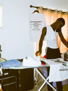 a man ironing clothes on an ironing board