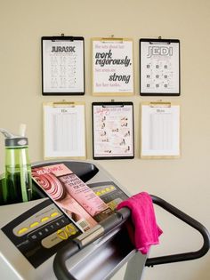 there are calendars hanging on the wall above a treadmill