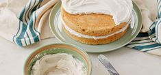 a cake on a plate next to a bowl of whipped cream