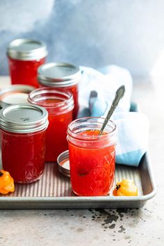 several jars filled with jam sitting on top of a tray