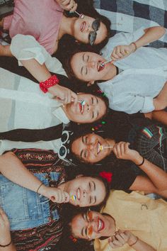 a group of young women laying on top of each other next to each other with their hands together