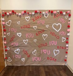 a valentine's day bulletin board is decorated with pom poms and hearts