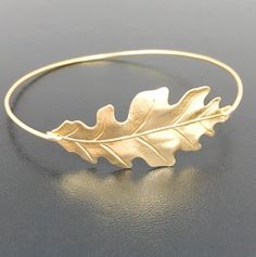 Oak Leaf Bracelet - Fall Leaf Jewelry - Autumn Leaf Bracelet A gold tone leaf charm will be transformed into a statement nature bracelet with choice of brass or 14k gold filled bangle band. The perfect fall wedding jewelry and fall bridesmaid gift. Also available with a silver tone leaf charm and bangle band choice of silver filled or sterling silver band. This fall bracelet stacks great with other bangles from my collection. Have fun stacking your Autumn bangle bracelet for the ultimate layered Leaf-shaped Gold Jewelry For Wedding, Gold Leaf-shaped Jewelry For Wedding, Adjustable Gold Leaf-shaped Jewelry, Gold Leaf Nature-inspired Jewelry, Nature-inspired Gold Leaf-shaped Jewelry, Fall Wedding Jewelry, Fall Bridesmaid, Women Nature, Fall Bridesmaids