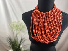 ### Orange Handmade Wooden Beads Necklace - Boutique Collection Multi-Strands Statement Piece Brighten up your accessory collection with our Orange Handmade Wooden Beads Necklace from the Boutique Collection. This bold and elegant multi-strands statement piece is meticulously handcrafted, making it a perfect choice for adding a touch of chic sophistication to any outfit. ### Features: - **Design Multiple strands of vibrant orange wooden beads intricately arranged to create a bold and eye-catching statement. - **Handmade Each necklace is expertly crafted by hand, ensuring a unique and high-quality piece. - **Materials Premium wooden beads selected for their rich color and lightweight feel, offering a comfortable yet striking appearance. - **Versatile Style Perfect for both casual and formal Elegant Multi-strand Wooden Beads, Multi-strand Wooden Beads For Jewelry Making, Wooden Multi-strand Beads For Jewelry Making, Large Round Beads Choker, Elegant Orange Beaded Necklace With Wooden Beads, Wooden Beads Choker Beaded Necklaces For Gifts, Wooden Bead Necklaces, Semi Casual, Hippy Gifts