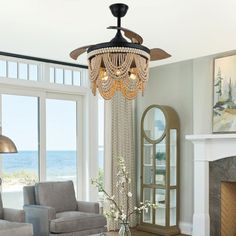 a living room filled with furniture and a chandelier hanging from the ceiling over a fire place