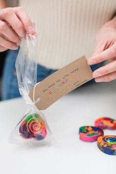 a person holding a bag with some candy in it next to other small candies