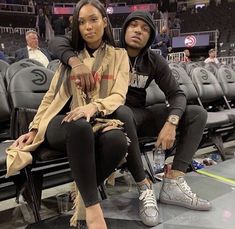 a man and woman sitting next to each other at a basketball game