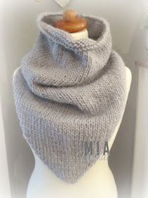 a gray knitted scarf sitting on top of a mannequin