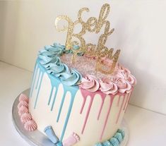 a birthday cake decorated with pink, blue and gold icing