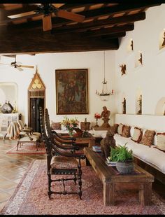 a living room filled with lots of furniture next to a fire place and ceiling fan