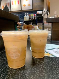 two plastic cups sitting on top of a counter next to each other in a restaurant