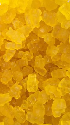 yellow gummy bears sitting in the middle of a pile