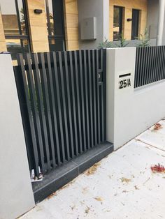 a black and white fence next to a building with a sign on it that reads 25a